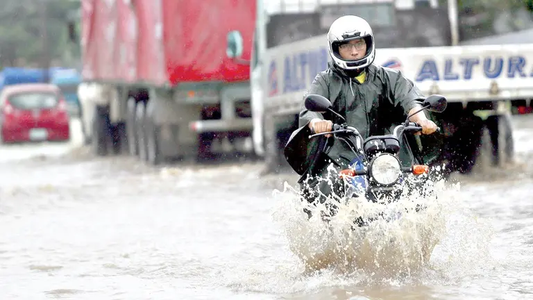 Un motociclista sortea el agua producto de las intensas lluvias en la capital cruce&ntilde;a./ APG