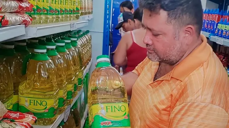 Un hombre sostiene una botella de aceite. Erbol
