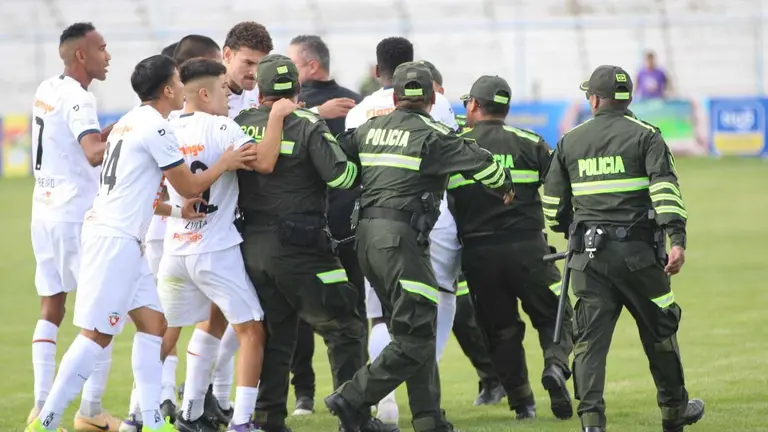 Jugadores de Royal Pari se enfrentan a efectivos policiales al abandonar el terreno de juego./ APG.