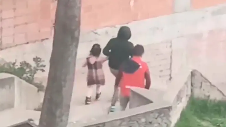 La mujer junto a la ni&ntilde;a abandondan el lugar donde ocurri&oacute; la agresi&oacute;n. Foto: captura video