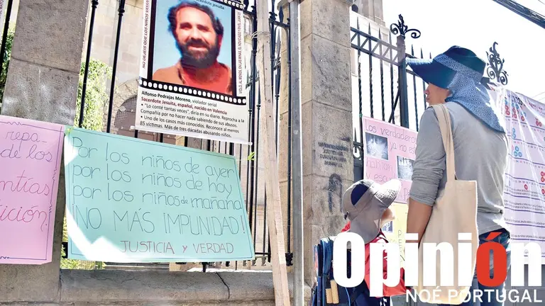 Una mujer y su hijo observan carteles puestos en el templo de la Compañía de Jesús en  Cochabamba. / NOÉ PORTUGAL