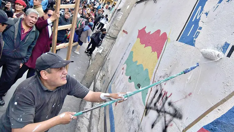 Evistas borran la sigla del MAS en la sede de dicho partido pol&iacute;tico, en La Paz./ APG