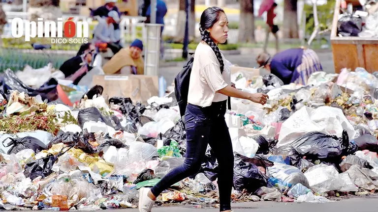 Una mujer camina entre la basura amontonada en la zona de la plaza San Sebasti&aacute;n./ DICO SOL&Iacute;S