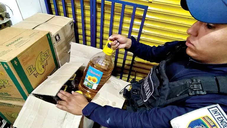 Un guardia municipal controla la venta de aceite, durante un operativo./ DICO SOL&Iacute;S