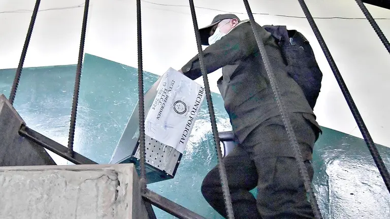 Un investigador de la Polic&iacute;a lleva material secuestrado en el caso Consorcio./ APG