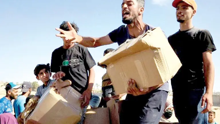 Personas claman por alimentos en la Franja de Gaza./ VATICAN NEWS