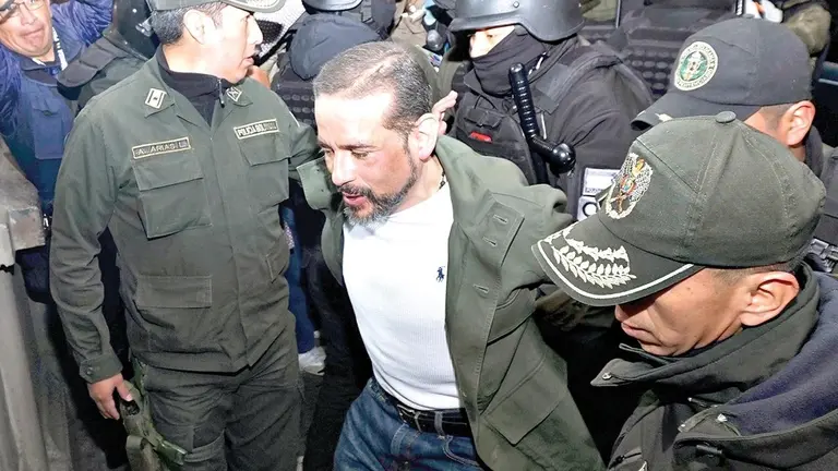 El gobernador Luis Fernando Camacho es escoltado por polic&iacute;as hacia su audiencia./ APG