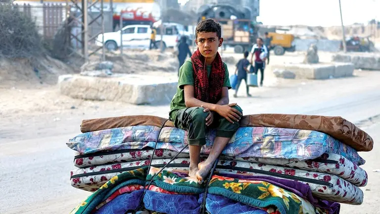 Los palestinos huyen a pie o en vehículos en medio de bombardeos ejecutados por Israel. / EL PAÍS