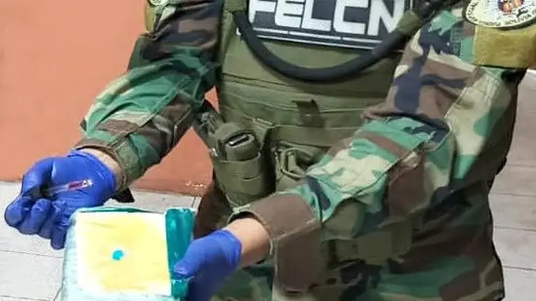 Imagen referencial de un agente que muestra un paquete de droga. UNITEL