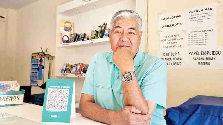 Alfredo Orellana expone el QR de su banca móvil en su negocio. / ISABEL ORELLANA
