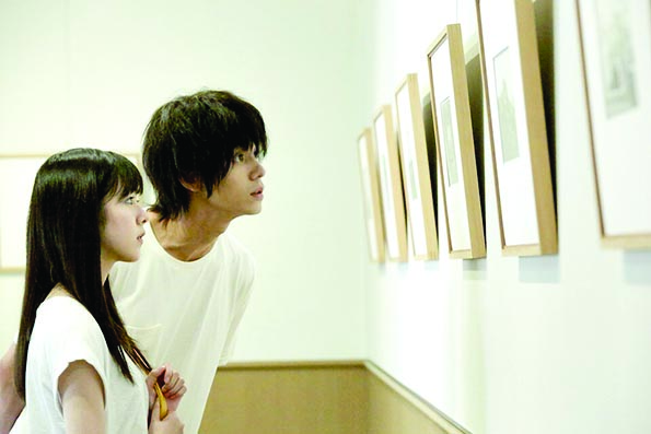 Un fotograma de ‘Asako I y II’, que muestra que todo comienza en una exposición de fotografía en Osaka. GRASSHOPPER FILM