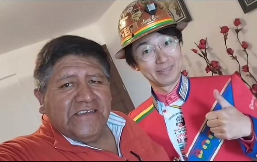El joven japonés con uno de los integrantes de la Banda Poopó. Urgente.bo