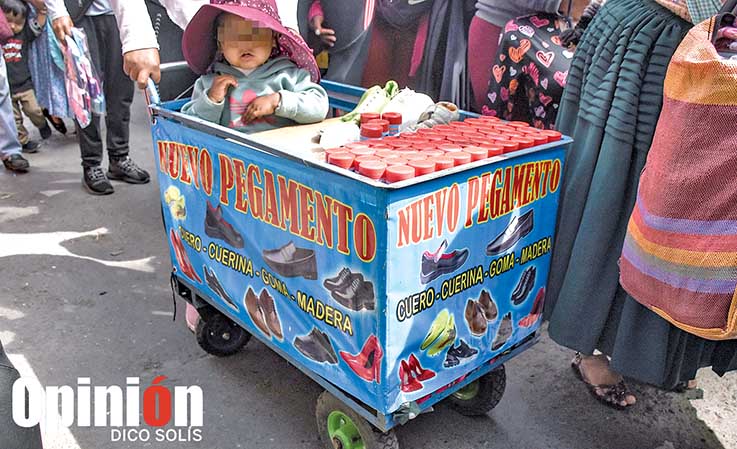 Una vendedora lleva a su niño en su carrito mientras ofrece productos, en San Antonio. / DICO SOLÍS