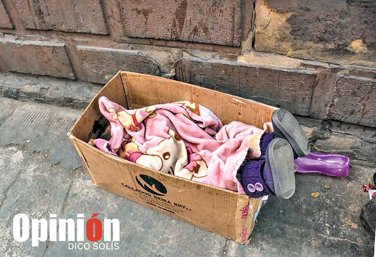 Un pequeño duerme en una caja de cartón, entretanto su mamá vende pastillas en la calle Hamiraya. / DICO SOLÍS