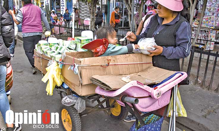 Una comerciante alimenta a su bebé en su puesto ambulante, en la calle Punata. / DICO SOLÍS