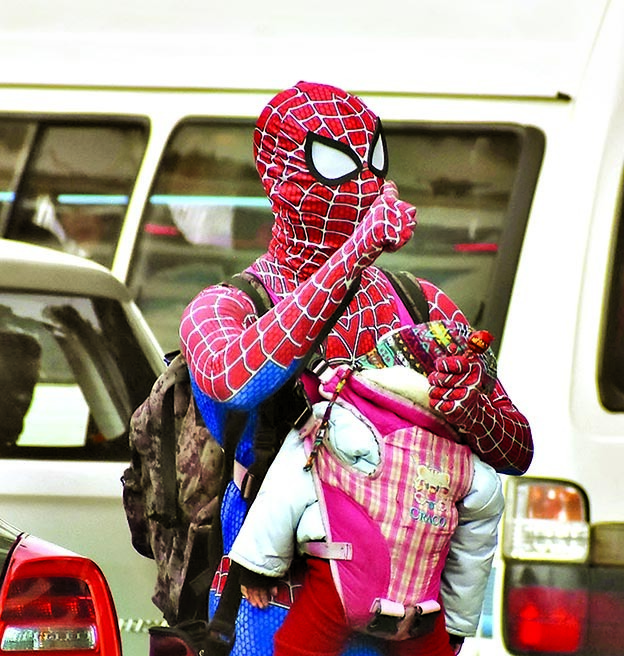 Álex Gómez, vestido de Spiderman, cargado de su nieto.